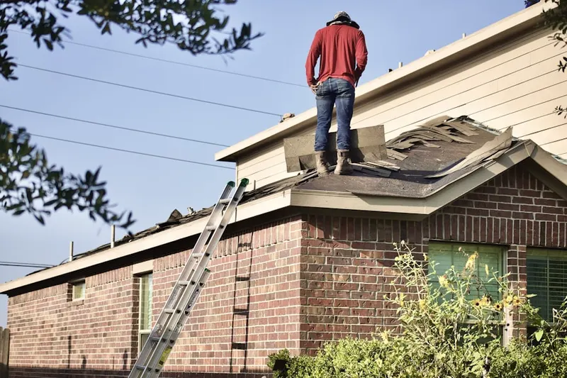 Professional roofer working on a residential roof in Harbor Gateway North